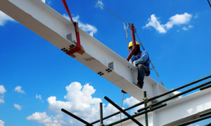 A construction worker operating on a crane at a high altitude.