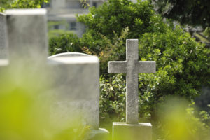 A cross-shaped gravestone in a cemetery.